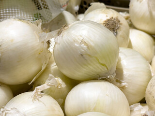 Fresh white onions in pile displaying natural textures and layers