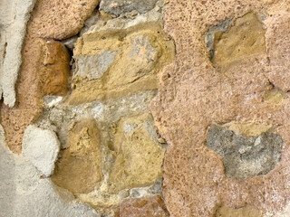 Aged rustic stone wall texture with varied earthy tones and rough surfaces