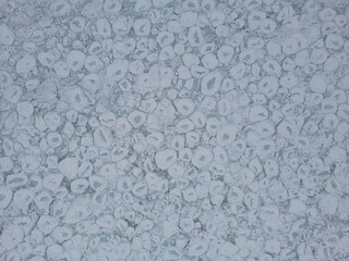 Aerial vertical view of ice floe breaking up on a lake with pancake-shaped portions of ice - Vue aérienne verticale de la banquise en dislocation sur un lac avec des portions de Glace en crêpe