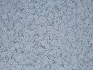 Obraz premium Aerial vertical view of ice floe breaking up on a lake with pancake-shaped portions of ice - Vue aérienne verticale de la banquise en dislocation sur un lac avec des portions de Glace en crêpe