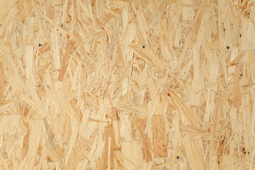 Close-up view of an oriented strand board (osb) wood panel, highlighting its unique texture of...