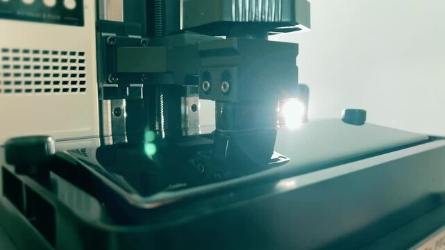 Build platform with dripping transparent red photosensitive resin in a modern SLA 3D printer