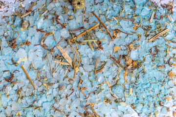 A close-up of blue bath salt mixed with chamomile and herbs, highlighting fine details and textures.