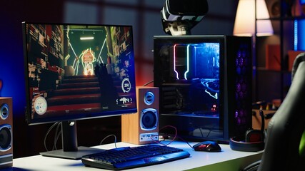 Computer screen showing FPS videogame left open at night in empty apartment with RGB lights. Close up shot of PC, keyboard and mouse on desk in living room with no people in