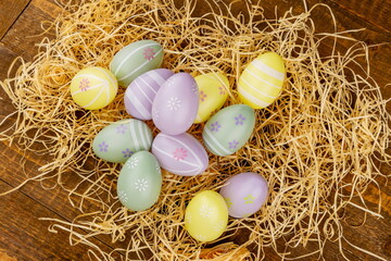 Uova di Pasqua di vari colori su paglia viste dall'alto 