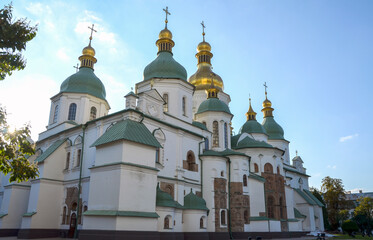 Historic Orthodox St Sophia Cathedral with golden domes and white walls, set against striking clear blue sky. Kyiv Ukraine. Representation of culture, architecture, and spiritual significance