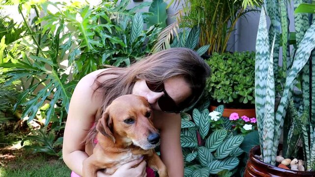 mulher faz carinho em cachorro caramelo 
