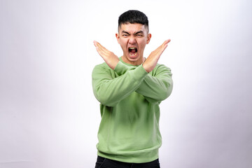 An Asian man in a green sweatshirt stands against a white background, crossing his arms in an 