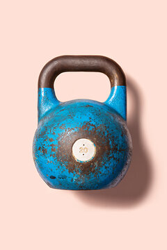 Blue kettlebell weight on a pink background