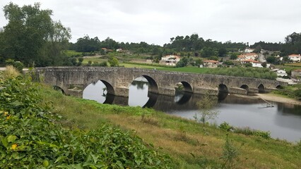 Panorâmica de ponte antiga, de pedras, de arquitetura medieval.