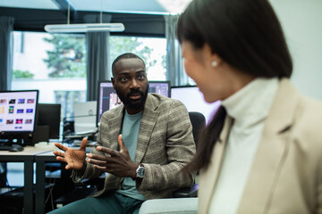Diverse business professionals having discussion in modern office workspace