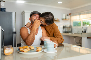 Middle-aged Hispanic couple sharing a loving moment during breakfast at home