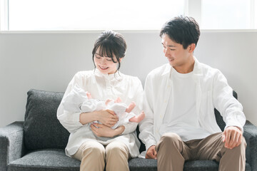 赤ちゃんを抱く夫婦・ママとパパ・新生児（子育て・育児）
