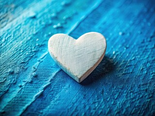 A charming tilt-shift miniature heart, painted white, rests on a textured blue background, a romantic DIY art piece.