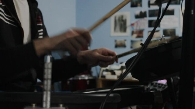 Manos de un baterista mexicano ensayando en su estudio en casa. 