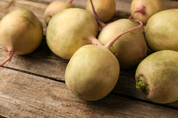 Whole fresh turnips on wooden table, closeup