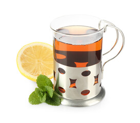 Glass of aromatic tea in holder, lemon and mint isolated on white