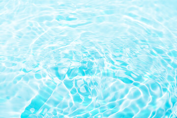 Blue water with ripples on the surface. Defocus blurred transparent blue colored clear calm water surface texture with splashes and bubbles. Water waves with shining pattern texture background.