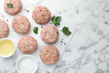 Many uncooked patties and spices on white marble table, flat lay. Space for text