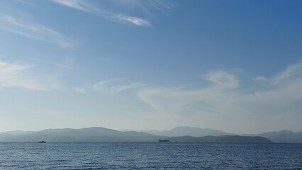 serene coastal scene calm ocean extending into the horizon under a bright blue sky filled with scattered