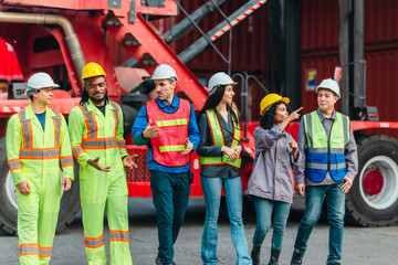 Obraz premium Team of Workers Walking and Talking in a Container Yard