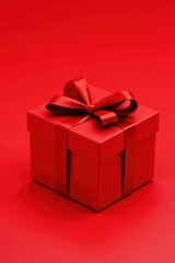 Obraz premium A crimson gift box elegantly adorned with a rich red ribbon, a perfect symbol of thoughtful giving and festive cheer.