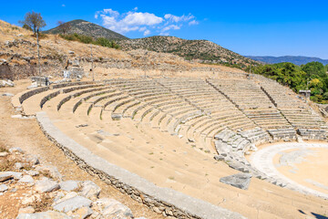 A large stone amphitheater with a stone wall surrounding it. Ruins of the ancient city of Philippi,...