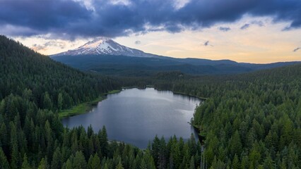 Majestic Mount Hood at dawn, reflected in a tranquil alpine Trillium Lake, surrounded by dark forest. Peaceful mountain scenery.  Oregon, United States