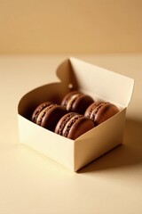 A delectable arrangement of chocolate macarons, meticulously placed within a gently opened pale box, rests on a soft beige surface.