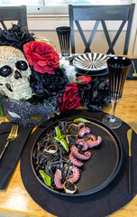 Octopus on a bed of black squid ink pasta with black garlic on a black  plate