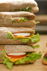 Fresh sandwiches stacked together on a wooden surface
