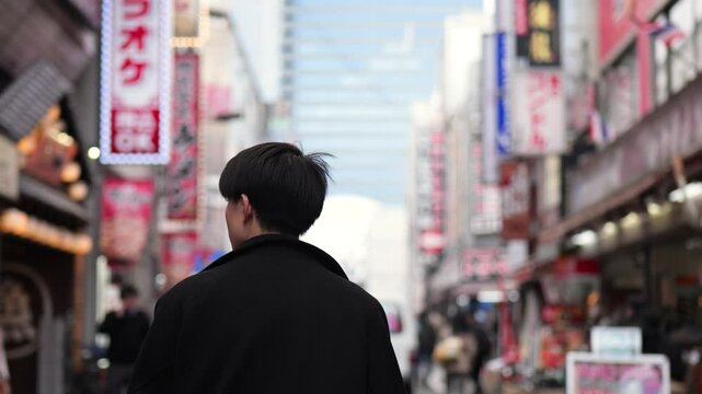 繁華街を歩く若い会社員の後ろ姿スローモーションフォローショット