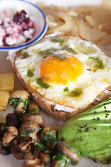 Delicious brunch with eggs, avocado, and mushrooms in a cozy setting