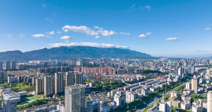 aerial time lapse video of the Jiujiang cityscape beside the Lushan mountain in the early morning of summer, Jiangxi Province, China