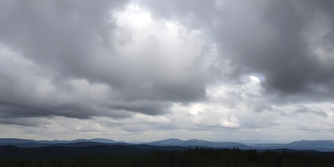 Fototapeta premium Heavy Clouds Moving Over a Forest with Thick Trees and Rolling Hills in the Distance