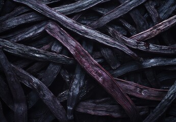 Close-Up View of Dried Purple Vanilla Beans Piled on Top of Each Other in a Dark Setting for Culinary or Decorative Use