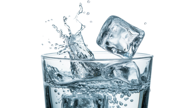 A glass of water with ice cubes splashing