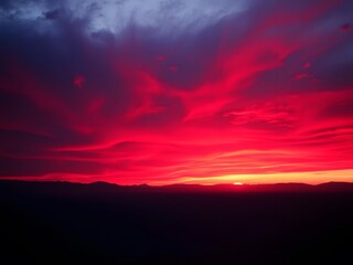  A striking and dramatic sunset with deep red, purple, and black hues over a vast lake, creating a surreal, almost mystical