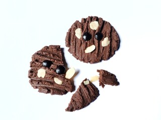 Broken chocolate cookies with chocochip topping and almond slices isolated on white background.
