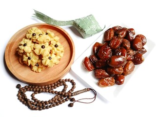 baked beans with meatDelicious semprit rose cookies or rose butter cookies with chocochips on wooden plate, dates, prayer beads and green ribbon ketupat on white background.