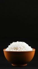 Bowl of White Cooked Rice Against a Black Background in Simple Still Life Food Photography