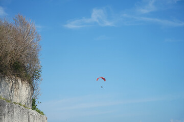 view of beautiful blue sky and cliffs with paragliding activity