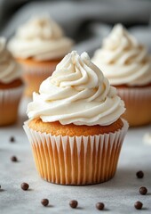 Sweet Vanilla Cupcake with Creamy Frosting Surrounded by Chocolate Sprinkles and Soft Gray Background Perfect for Bakery Promotions and Culinary Displays