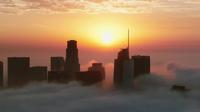 Stunning view of Downtown Los Angeles at sunrise, cloaked in fog, highlighting the iconic skyline as morning light enhances the serene atmosphere, perfect for exploration and enjoyment. LA, USA