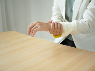 Young Asian woman feels numbness and severe pain in her wrist Caused by sitting and working for a...