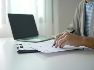 Fototapeta premium Young businesswoman holds a resume and evaluates it. Views the personal history of job applicants. Recruitment concept