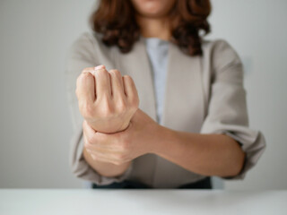 Young Asian woman feels numbness and severe pain in her wrist Caused by sitting and working for a...