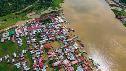 Aerial View of a Riverfront Community in the Amazon Rainforest of Colombia Surrounded by Lush Greenery