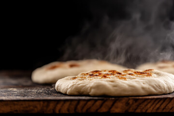 Freshly Baked Flatbreads with Golden Brown Grill Marks and Rising Steam on a Dark Background, Perfect for Wraps, Sandwiches, or Appetizers
