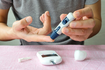 Woman's hands checking diabetes and hyperglycemia with digital blood sugar meter. Healthcare and medical concept	